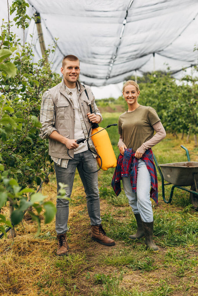 Portrait of a man and a woman working in the orchard. - Foto, Imagen