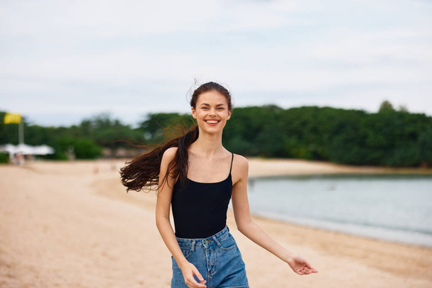 γυναίκα διακοπές χαλαρώστε το ηλιοβασίλεμα πρόσωπο χαμόγελο ταξίδια τρέχει θαλασσινό νερό ανατολή θετική παραλία κορίτσι καλοκαίρι μαλλιά αντίγραφο lifestyle ωκεανός μακρύς νέος χώρος - Φωτογραφία, εικόνα