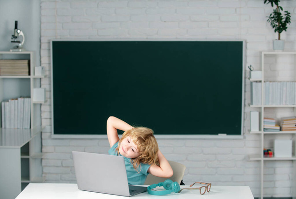 Portrait of attractive cheerful boy using laptop, rest and relaxing after school lesson - Foto, afbeelding