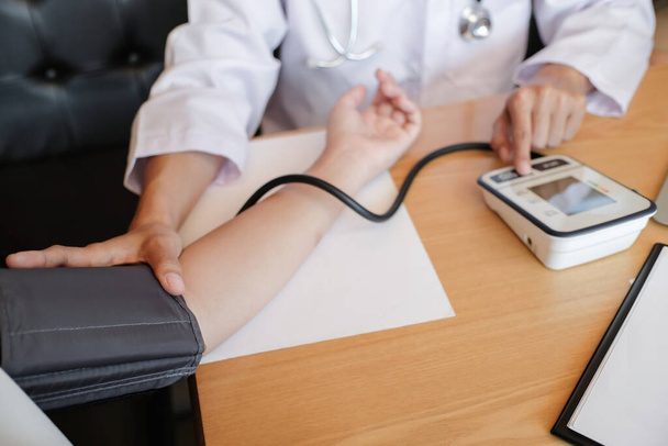 Médico revisando la presión arterial del paciente. Asistencia sanitaria. - Foto, Imagen