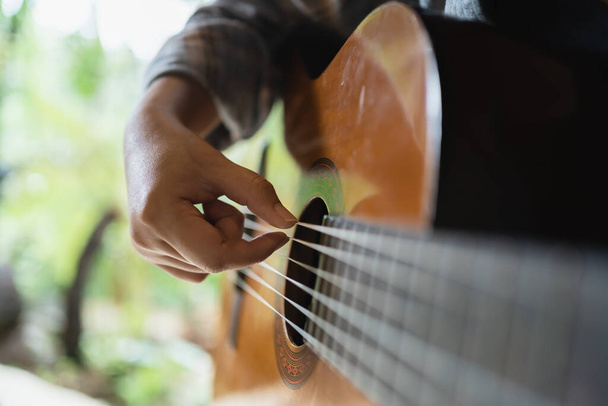 Счастливая молодая женщина руки играют акустической гитары музыкант в одиночку сочинять инструментальную песню меньше на играть на гитаре. - Фото, изображение