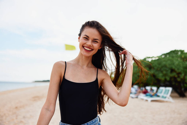 tenger nő futás strand természet mosoly víz óceán pihenés nyár homok nyaralás másolás tér séta naplemente nyaralás gyönyörű mosolygós gondtalan ruha fiatal - Fotó, kép
