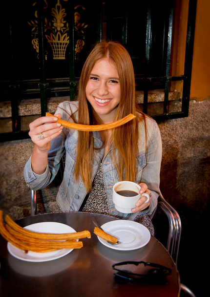 estudante americano turista menina sentado tendo espanhol típico chocolate quente com churros sorrindo feliz
 - Foto, Imagem
