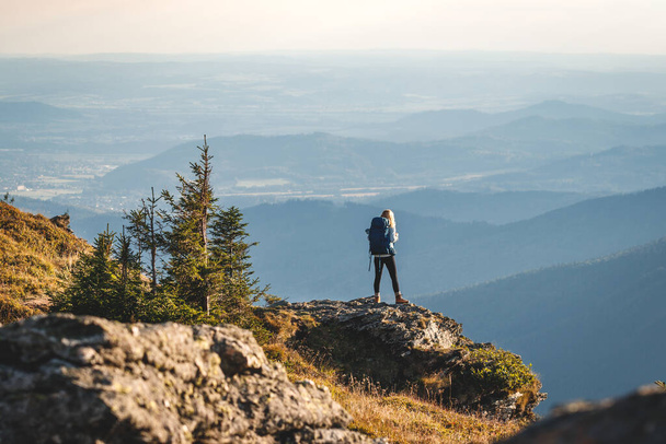 Dağ tırmanışı. Sırt çantalı bir kadın dağlarda yürüyüş yapıyor. Doğada macera ve keşif - Fotoğraf, Görsel