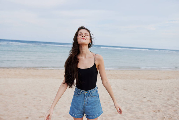 アクティブな女性笑顔飛行休暇サンセットヘア若い幸せウォーキング旅行美容海人ランニングライフスタイル長い夏のビーチ美しいポジティブな体 - 写真・画像