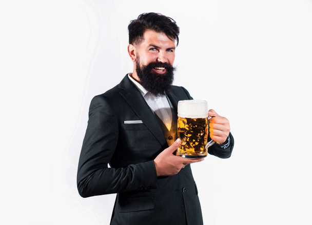 Hipster with beard and mustache in suit drinks beer after working day. Germany Bavaria. Beer time. Barman holding a pint cup of beer - Foto, imagen
