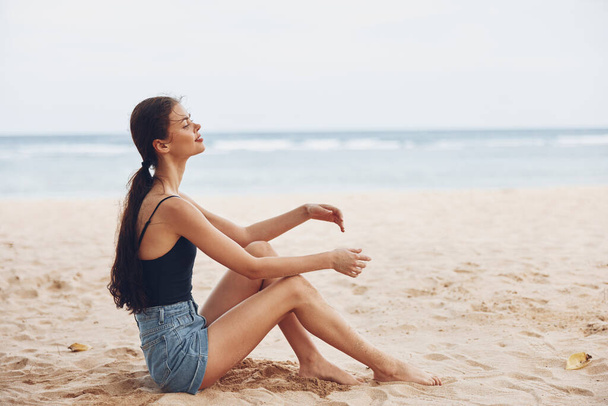 mujer atractiva chica verano sentado persona bronceado largo moda libertad naturaleza vacaciones sexy feliz bonita sonrisa mar vacaciones arena pelo playa viajes - Foto, imagen