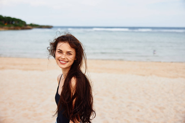 Кавказский женский берег ходьба морской отдых работает летом природа молодой песчаный пляж красивые поездки берега открытая улыбка мирная девушка человек океан - Фото, изображение