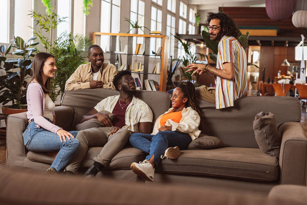 group of multiracial people coworkers, in modern coworking sitting on sofa talking at meeting, college students - Fotó, kép