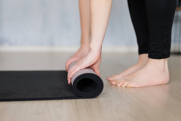 koncepce jógy a meditace - zblízka bosá žena připravuje podložku na jógu pro trénink doma - Fotografie, Obrázek