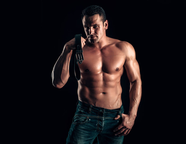 Handsome muscular man posing. Guy in jeans with perfect abdominal muscles - Foto, immagini