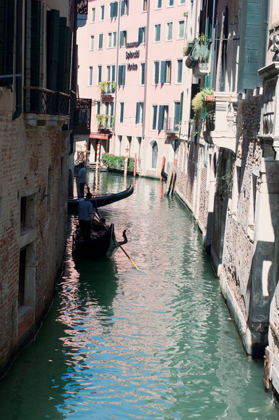 Narrow Venetian canal with red building and reflection in the water. Light and shadow - Foto, Imagen