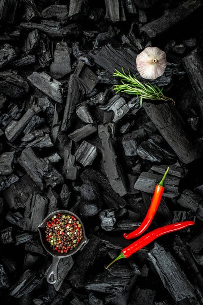 BBQ grill coal texture with fresh herbs, spices and kitchen utensils, cooking background, place for text, top view, - Foto, afbeelding