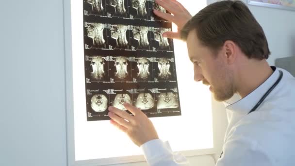 Um vertebrologista examina uma imagem de raio-X de uma paciente do sexo feminino coluna vertebral no hospital. Conceito de medicina, saúde e pessoas - Filmagem, Vídeo