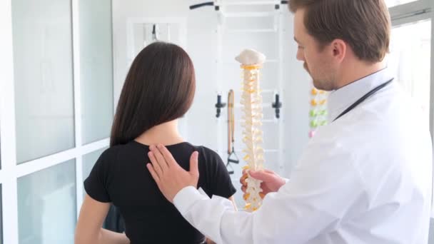 Paciente femenina examinando columna vertebral en fisioterapeuta del centro de vertebrología. Una mujer en una consulta con un verbólogo. - Imágenes, Vídeo
