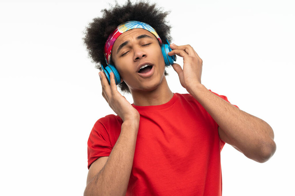 Leisure. Dark-skinned young guy with headphones looking contented - Фото, зображення