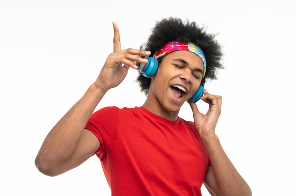 Leisure. Dark-skinned young guy with headphones looking contented - Photo, image
