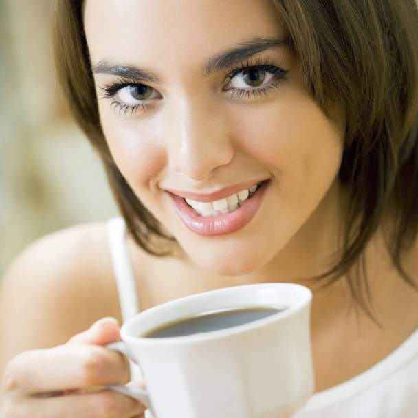 Young happy smiling woman drinking coffee, at home - Foto, imagen