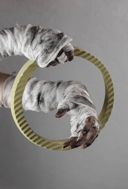 Mummy hands through the circle  on gray background. Halloween concept - Photo, Image