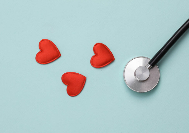 Mavi arka planda kalpleri olan steteskop. Aşk konsepti, kalp hastalığı teşhisi - Fotoğraf, Görsel