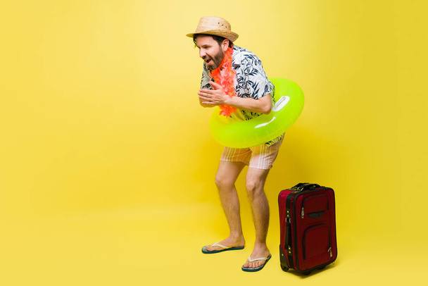 Handsome mid-adult man wearing shorts with an inflatable ready to go to the pool during his summer vacations - Фото, зображення