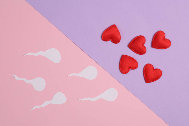 Spermatozoen mit Herzen auf pastellfarbenem Hintergrund. Liebe, Empfängnis, Sexualkonzept - Foto, Bild