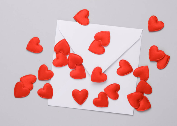 White envelope with a hearts on gray background. Love, romance, valentine's day, February 14 concept - Photo, Image
