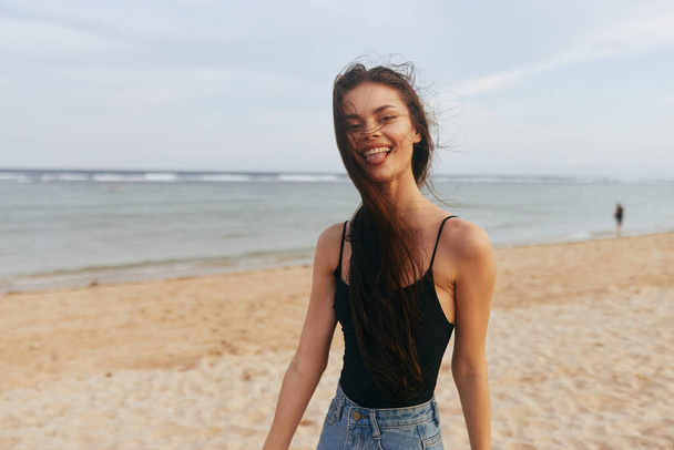 γυναίκα τρόπος ζωής νεαρή γυναίκα καλοκαιρινές διακοπές θάλασσα ωκεανός καυκάσιος ηλιοβασίλεμα χαμόγελο ελευθερία διακοπές ενηλίκων παραλία μαλλιά τροπικά μακριά άμμο κορίτσι περπάτημα φύση - Φωτογραφία, εικόνα