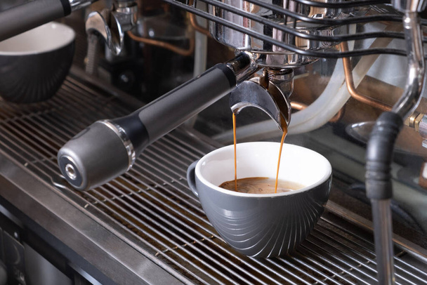 A cup of coffee, espresso, latte in a professional coffee machine. - Valokuva, kuva