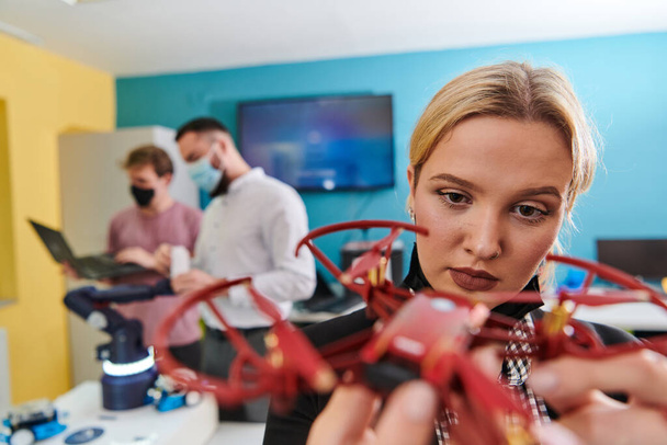  Een groep studenten die samenwerken in een laboratorium, toegewijd aan het verkennen van de aerodynamische mogelijkheden van een drone.  - Foto, afbeelding
