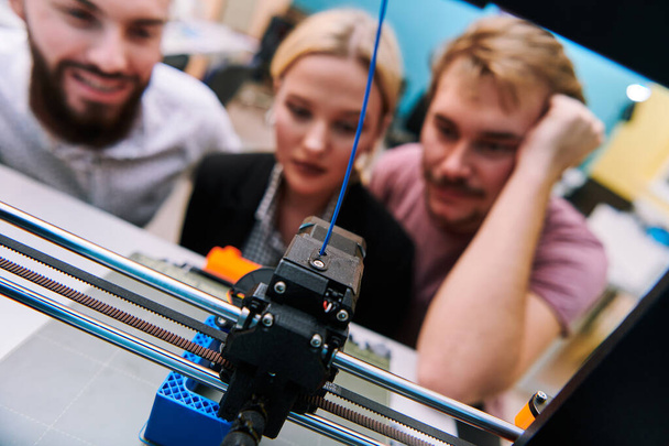 A group of colleagues working together in a robotics laboratory, focusing on the intricate fields of robotics and 3D printing. Showcase their dedication to innovation, as they engage in research - Photo, image