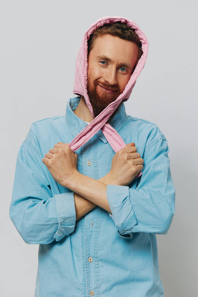 Αστείος άντρας με ροζ καπέλο σε ανοιχτό γκρι φόντο. Χαμογελάστε και θετικά συναισθήματα. Υψηλής ποιότητας φωτογραφία - Φωτογραφία, εικόνα