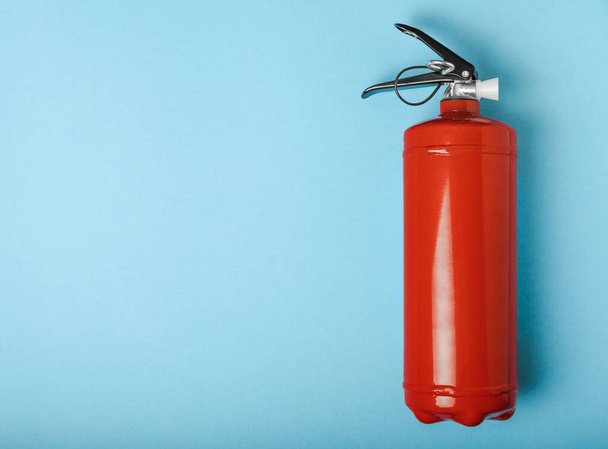 Fire extinguisher on a blue background . Fire protection, home fire extinguisher. home security concept. Place for text. Copy space.banner - Foto, Imagen