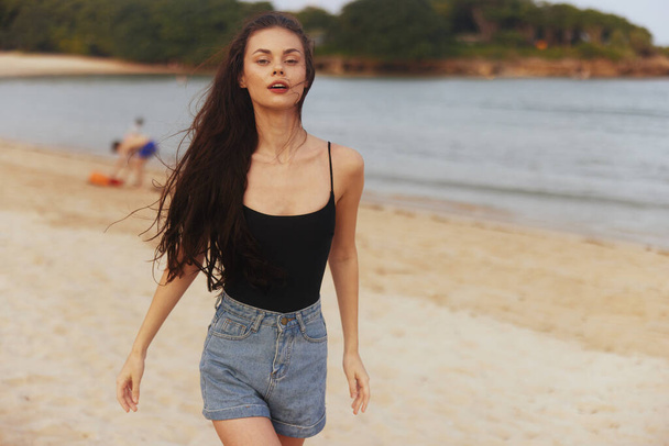 γυναίκα Ωκεανό φόρεμα ενηλίκων ηλιοβασίλεμα lifestyle πρόσωπο νεαρή παραλία ήλιος καλοκαίρι ακτή τροπική θάλασσα φως του ήλιου περπάτημα άμμο χαμόγελο απόλαυση διακοπές ευτυχία - Φωτογραφία, εικόνα