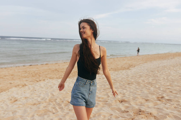 jean γυναίκα ωκεανός ομορφιά ελευθερία ήλιος διακοπές παραλία θηλυκό καλοκαίρι ουρανό lifestyle θάλασσα ενηλίκων με τα πόδια ξέγνοιαστο ηλιοβασίλεμα ευτυχισμένη άμμο χαμόγελο καυκάσιος - Φωτογραφία, εικόνα