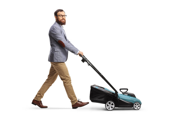 Full length shot of a man using a lawnmower and looking at camera isolated on white background - Photo, image