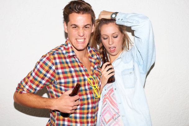 Portrait of gen z couple at party, beer and drunk face, hipster fashion with university youth culture. Drinks, woman and man in crazy picture at college event, happy friends on white wall background - Fotografie, Obrázek