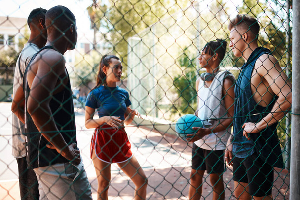 Todos hablan el idioma del baloncesto. un grupo de jóvenes deportistas charlando en una cancha deportiva - Foto, imagen