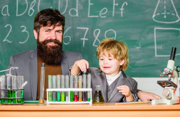 Laboratory test tubes and flasks with colored liquids. father and son at school. researcher carrying out scientific research in lab. Back to school. teacher man with boy. Innovation starts with us. - Foto, afbeelding