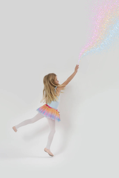 Studio portrait of beautiful little princess playing with magic fairy dust from her hand - Foto, imagen