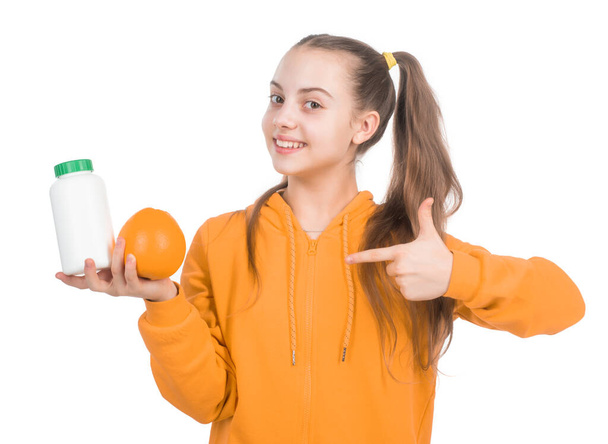 organic food supplement. choice between natural products and pills. presenting vitamin product. child with orange flavored pill. effervescent tablet for kids. girl pointing finger on vitamin c. - Photo, image