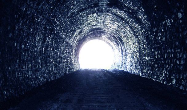 Luz del día brillante al final de un viejo túnel oscuro de piedra, el concepto de ir a otro mundo. - Foto, Imagen