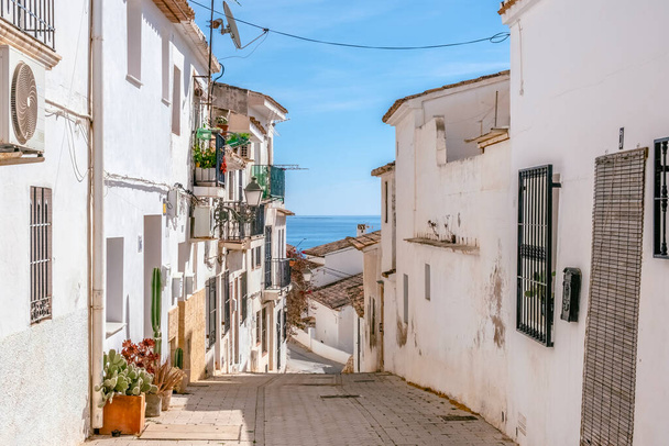 狭い通りと白塗りの家とアルテア旧市街。アリカンテ県、バレンシア、スペインの地中海に近いアルテアの小さな絵のような村の建築. - 写真・画像