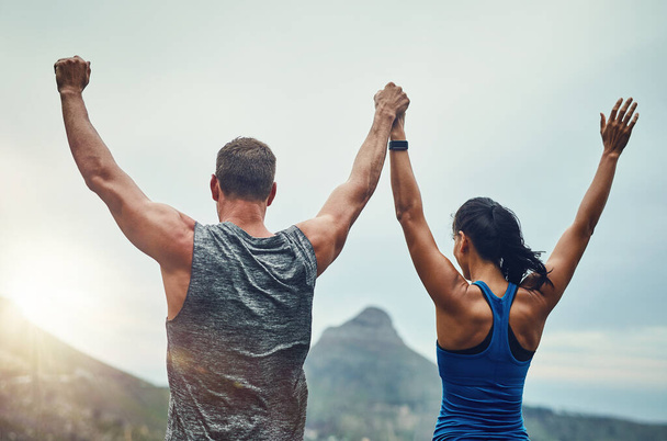 Couple, celebration and arms up in nature for training, workout or exercise to run a marathon, competition or tournament. People, winning and happy for freedom, sports goal or achievement. - Photo, Image