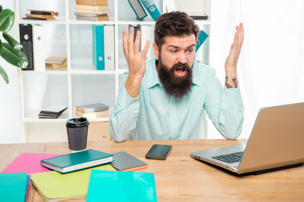 Angry businessman working on laptop at office desk, work. - Zdjęcie, obraz