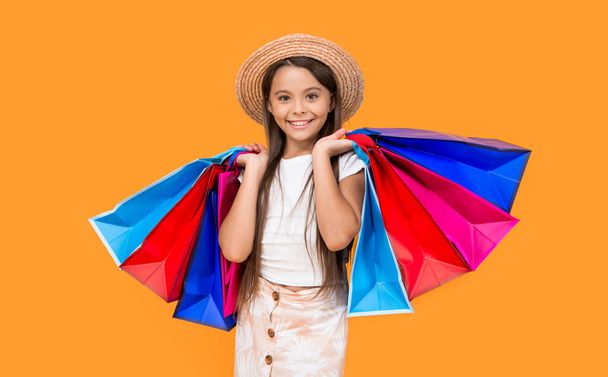 happy teen girl with shopping bags on yellow background. - Foto, Imagem