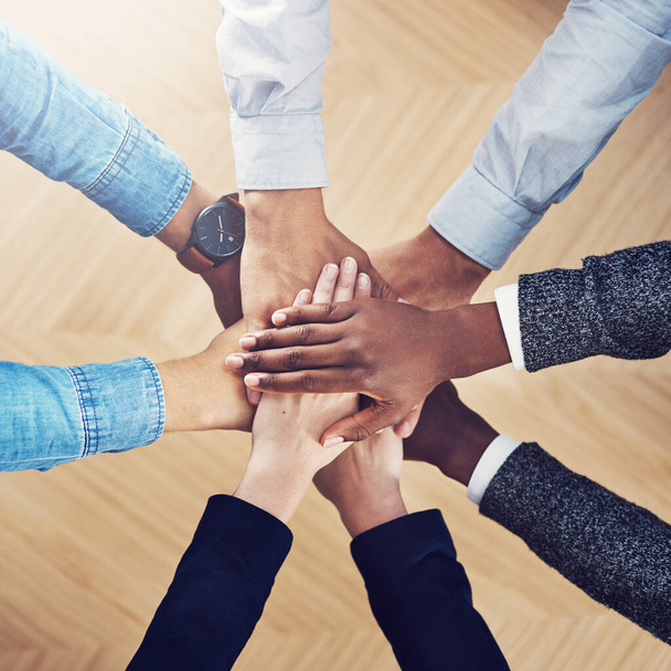 Diversity, partnership or hands of business people in support for faith, teamwork or strategy in office. Closeup, above or employees in group collaboration with hope or mission for goals together. - 写真・画像