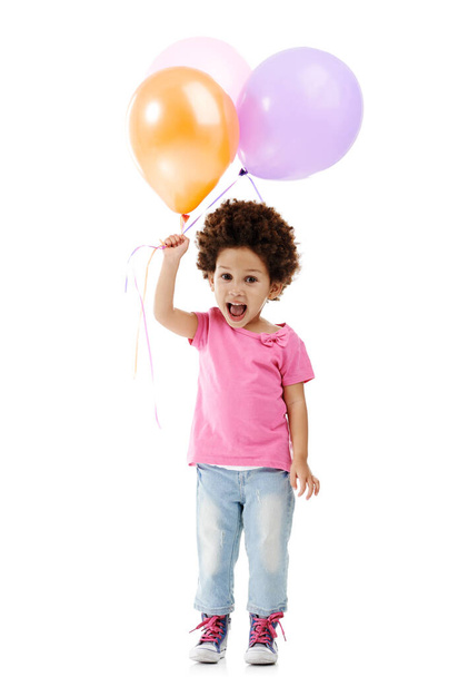 Ας διασκεδάσουμε. Στούντιο πλάνο ενός χαριτωμένου μικρού κοριτσιού κρατώντας ένα μάτσο μπαλόνια σε ένα λευκό φόντο - Φωτογραφία, εικόνα