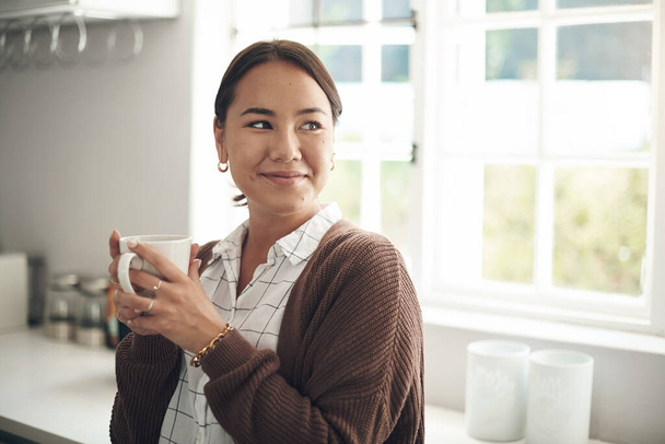 Στο σπίτι για να απολαύσετε μια κρύα μέρα. μια νεαρή γυναίκα που πίνει καφέ στο σπίτι - Φωτογραφία, εικόνα