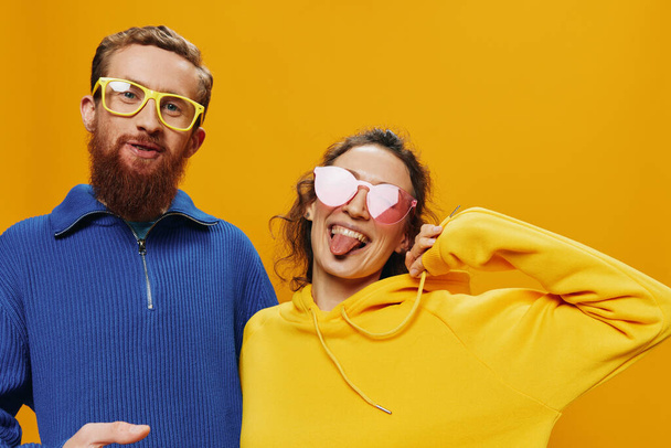 Чоловік і жінка посміхаються весело і криві окуляри, на жовтому тлі, символи знаки і жести рук, сімейна стрілянина, молодята. Високоякісна фотографія - Фото, зображення
